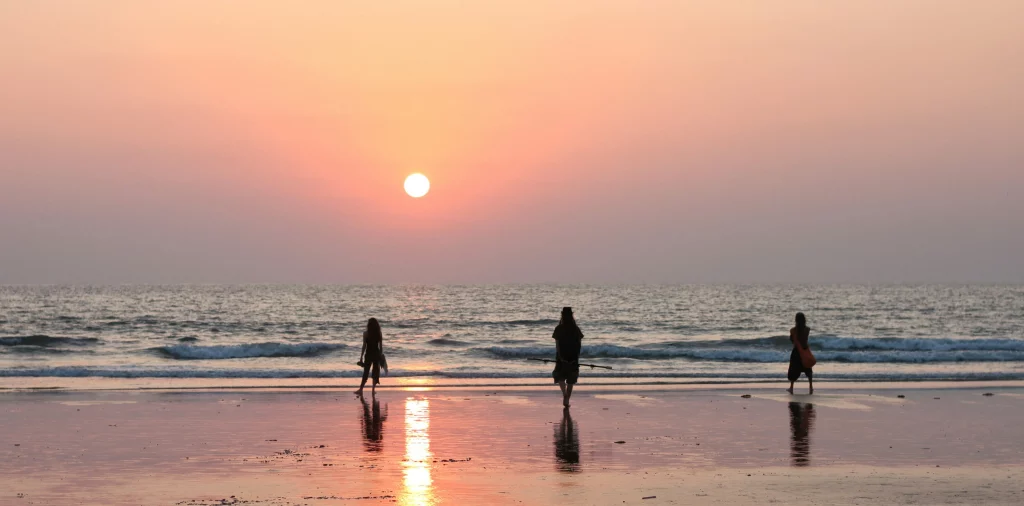 Group enjoying sunset at a Goa beach shoreline